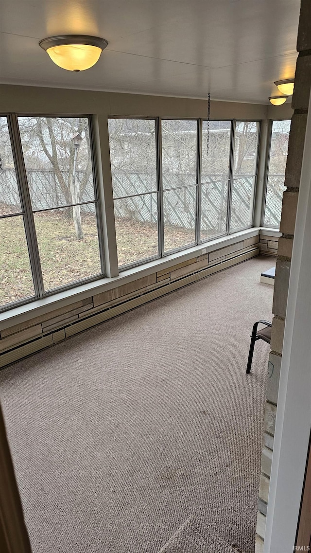 unfurnished sunroom with a baseboard heating unit