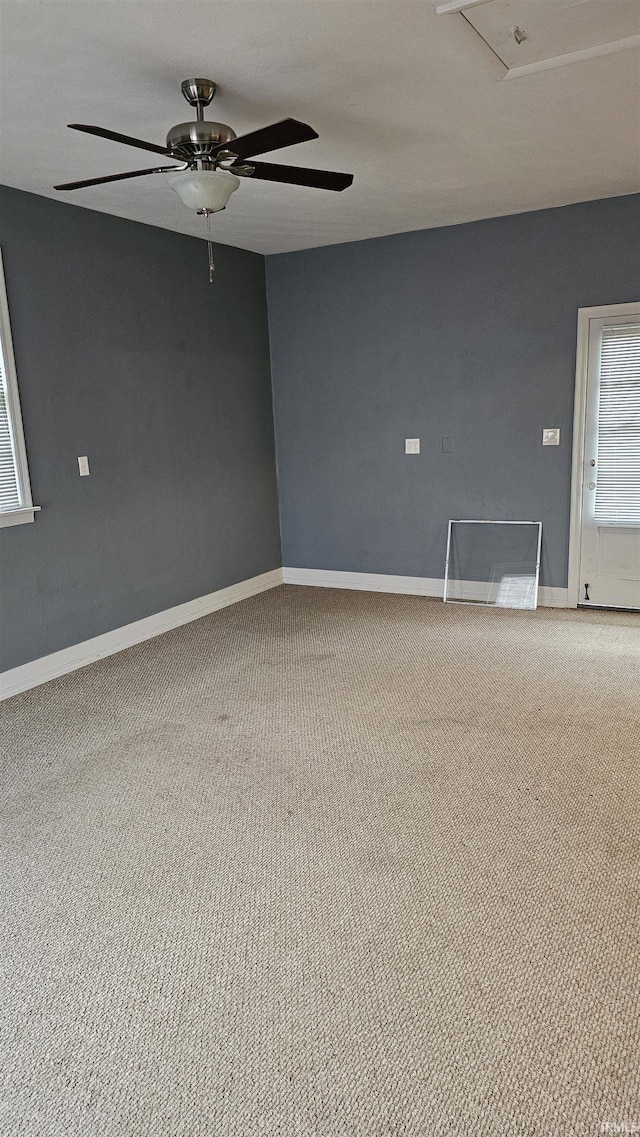 carpeted spare room featuring ceiling fan