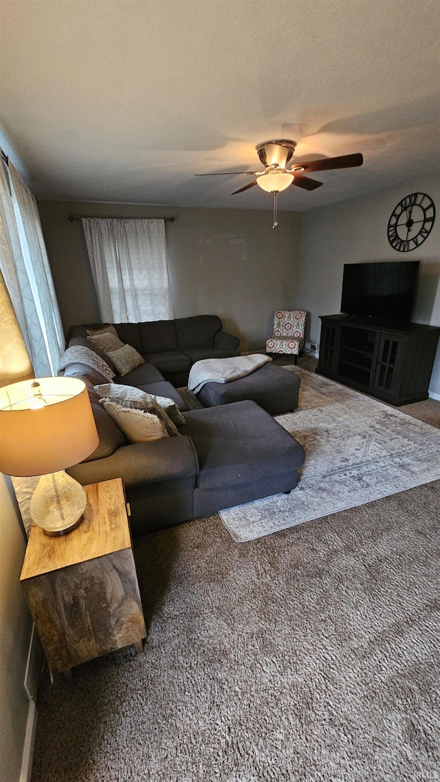 carpeted living room featuring ceiling fan and a textured ceiling