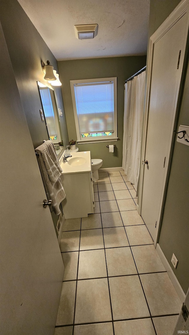 bathroom featuring vanity, tile patterned floors, a textured ceiling, and toilet