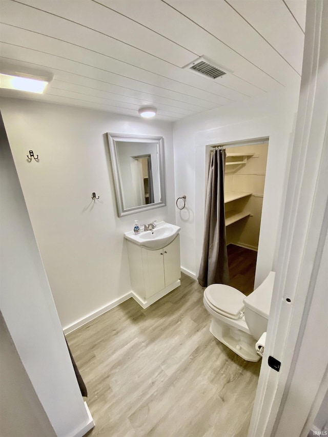 bathroom featuring vanity, hardwood / wood-style floors, and toilet