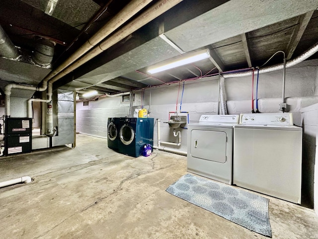 basement featuring heating unit, sink, and washer and dryer