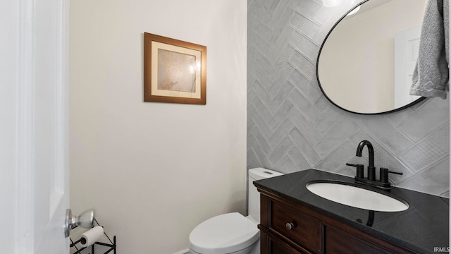 bathroom featuring vanity, toilet, and tile walls