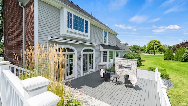 wooden terrace with a fireplace and a lawn