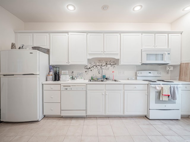 kitchen featuring sink, white appliances, light tile patterned floors, tasteful backsplash, and white cabinets