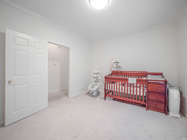 carpeted bedroom featuring crown molding and a crib