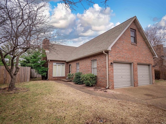 view of side of property featuring a garage and a lawn