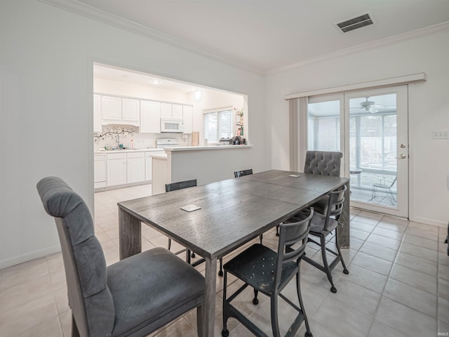 dining space with crown molding, a healthy amount of sunlight, and light tile patterned flooring