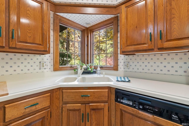 kitchen with backsplash, sink, and paneled dishwasher