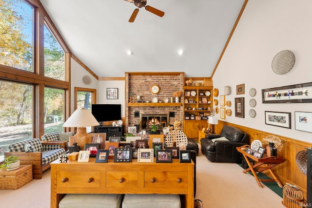 carpeted living room featuring ceiling fan, a brick fireplace, crown molding, and high vaulted ceiling