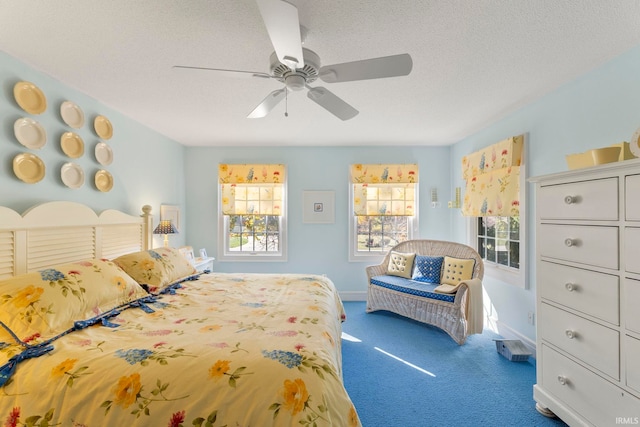 bedroom with ceiling fan, dark carpet, and a textured ceiling