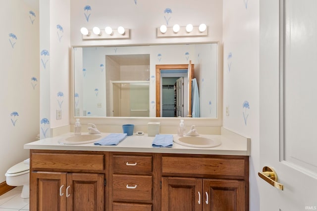 bathroom with vanity, toilet, tile patterned floors, and walk in shower