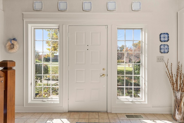 doorway featuring a healthy amount of sunlight and light tile patterned floors