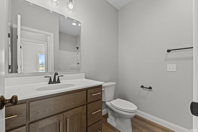 bathroom with vanity, hardwood / wood-style flooring, a shower, and toilet