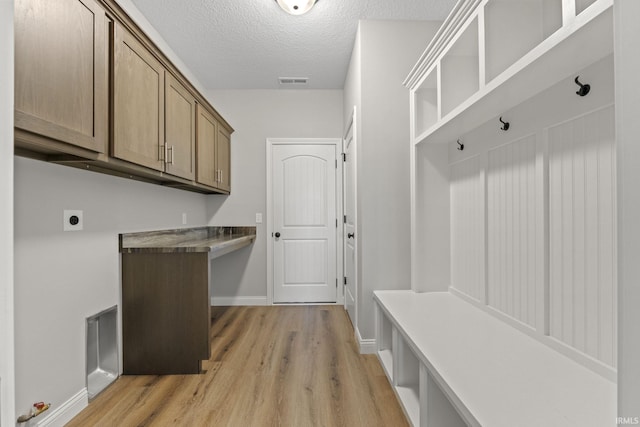 mudroom featuring a textured ceiling and light wood-type flooring