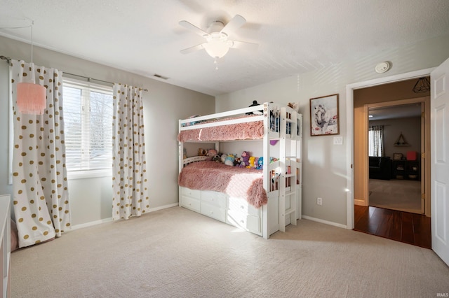 carpeted bedroom with ceiling fan and a textured ceiling