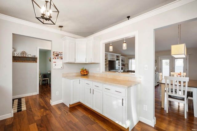 kitchen with dark hardwood / wood-style floors, pendant lighting, white cabinets, a chandelier, and crown molding