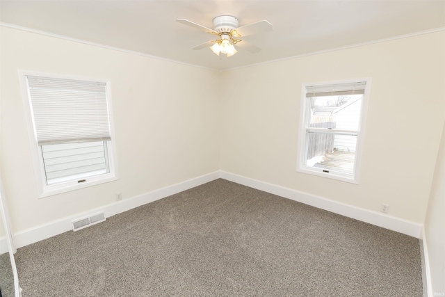 carpeted spare room with ceiling fan and ornamental molding