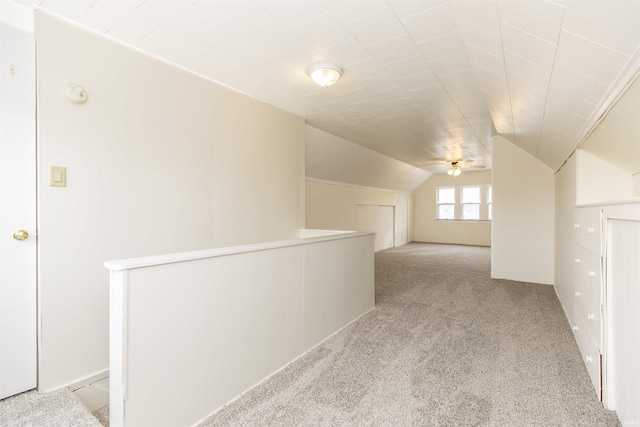 corridor featuring lofted ceiling and light carpet