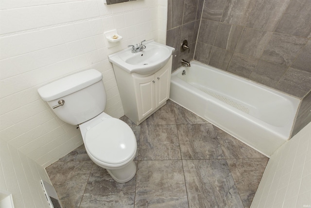 full bathroom featuring tile walls, tile patterned flooring, vanity, toilet, and washtub / shower combination