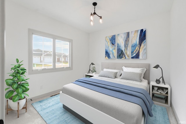 carpeted bedroom featuring a notable chandelier