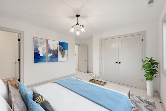 bedroom featuring an inviting chandelier and a closet