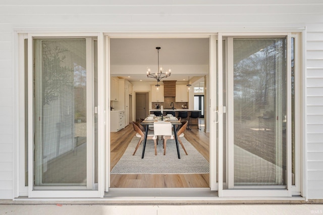 dining room with sink, hardwood / wood-style floors, and a chandelier