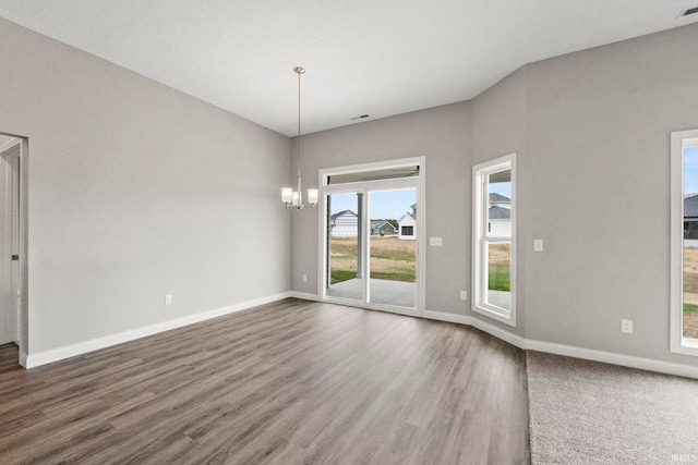 empty room featuring dark hardwood / wood-style floors and a chandelier