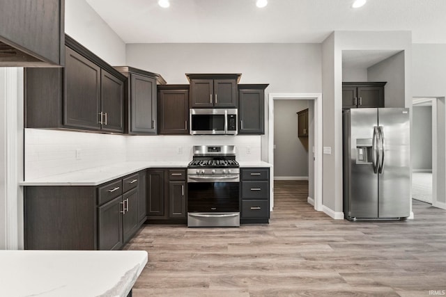 kitchen with decorative backsplash, dark brown cabinets, light hardwood / wood-style floors, and appliances with stainless steel finishes