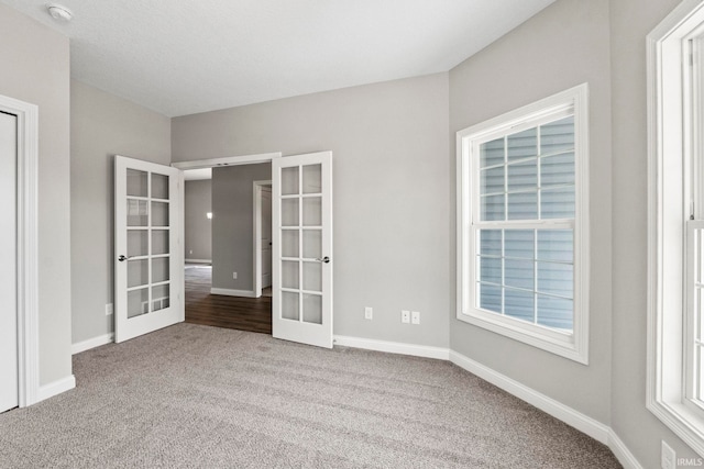 carpeted spare room with french doors