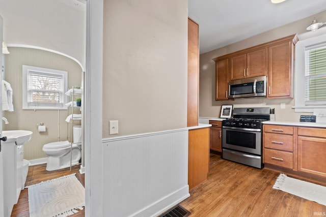 kitchen featuring appliances with stainless steel finishes and light hardwood / wood-style floors