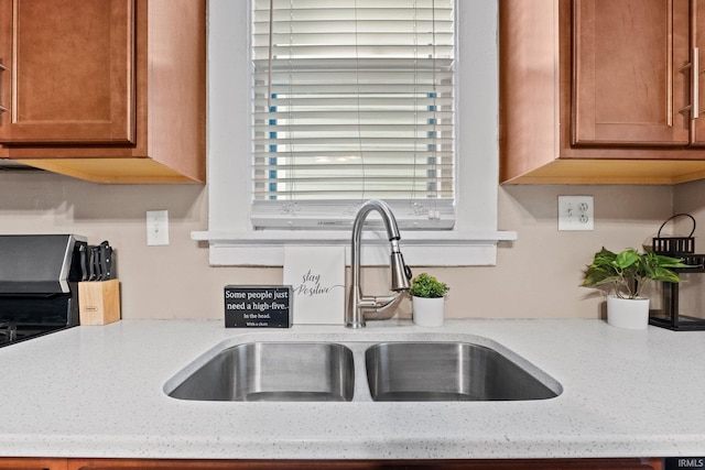 kitchen featuring light stone counters and sink