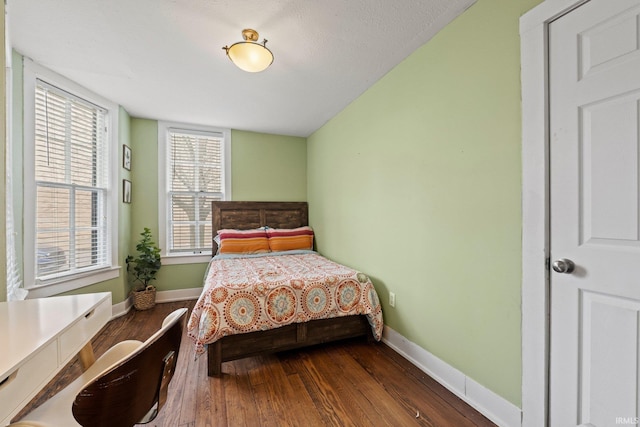 bedroom with dark hardwood / wood-style floors