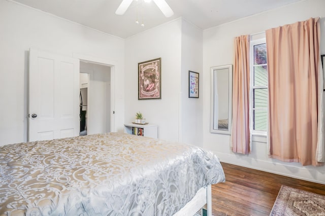 bedroom with ceiling fan, dark hardwood / wood-style floors, and refrigerator