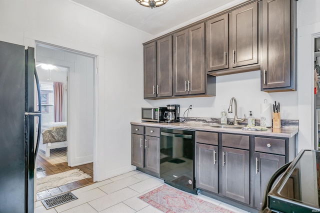 kitchen featuring sink, dark brown cabinets, and black appliances