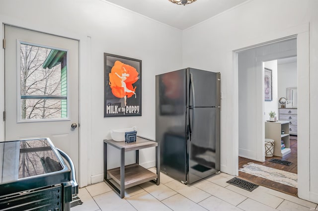 interior space with black fridge and light tile patterned floors