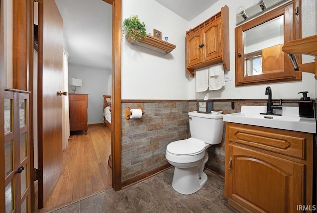 bathroom with vanity, wood-type flooring, tile walls, and toilet