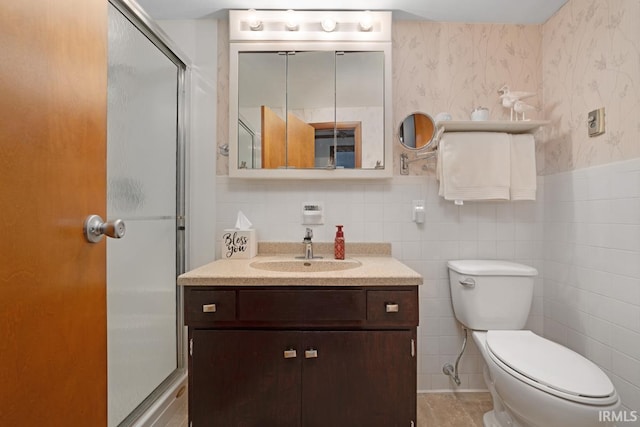 bathroom with vanity, toilet, tile walls, and walk in shower