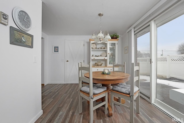 dining area with dark hardwood / wood-style floors and a chandelier