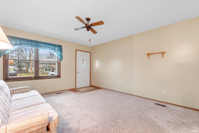 unfurnished living room with ceiling fan and carpet