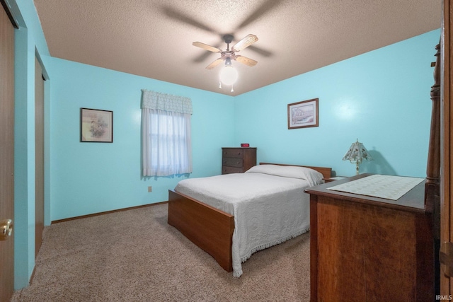 carpeted bedroom featuring ceiling fan and a textured ceiling