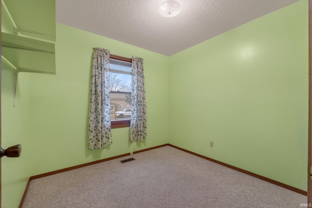 empty room featuring carpet flooring and a textured ceiling