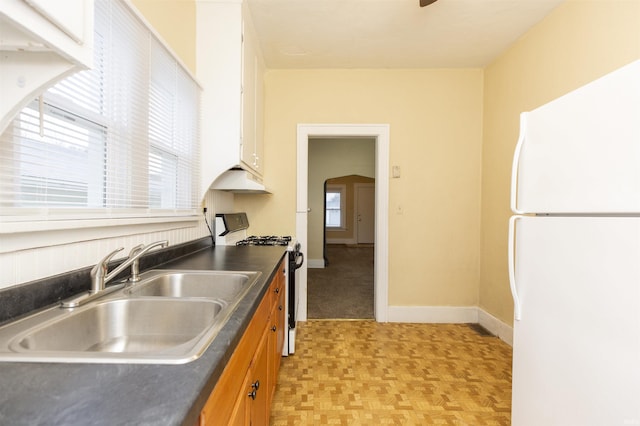 kitchen with black gas range, sink, a healthy amount of sunlight, and white refrigerator