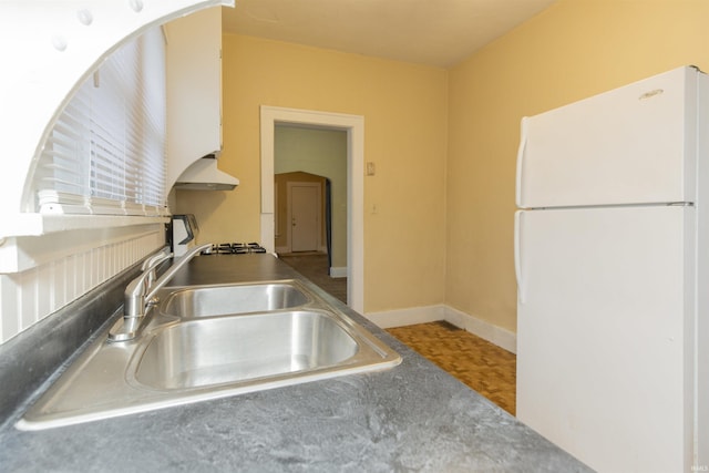 kitchen featuring white refrigerator and sink