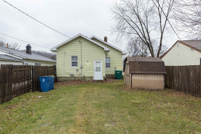 back of house featuring a shed and a lawn