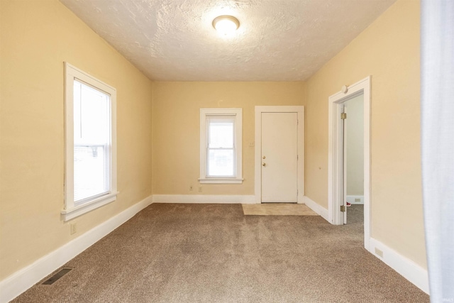 unfurnished room featuring carpet floors and a textured ceiling