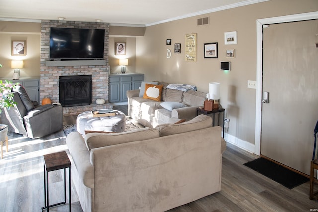 living room with dark wood-type flooring, ornamental molding, and a fireplace