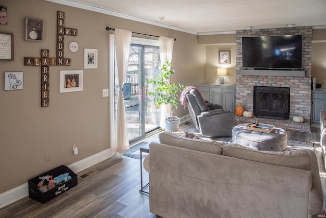 living room featuring hardwood / wood-style flooring, crown molding, a textured ceiling, and a fireplace