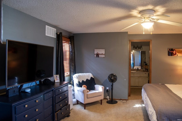 carpeted bedroom featuring ensuite bathroom, ceiling fan, and a textured ceiling