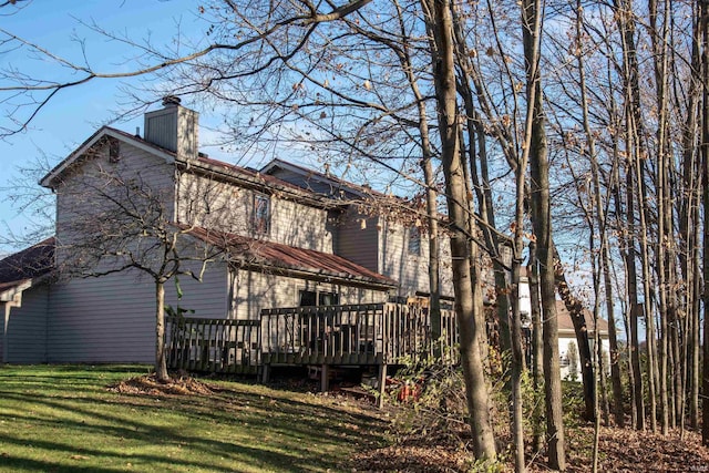 back of house featuring a yard and a deck